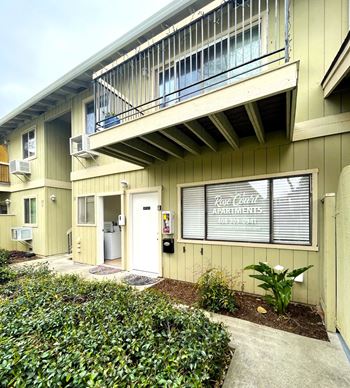 an apartment building with a porch and a sign in the window